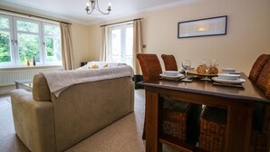 Un dormitorio con cama, una mesa de comedor con sillas y vistas al exterior a través de amplias ventanas.