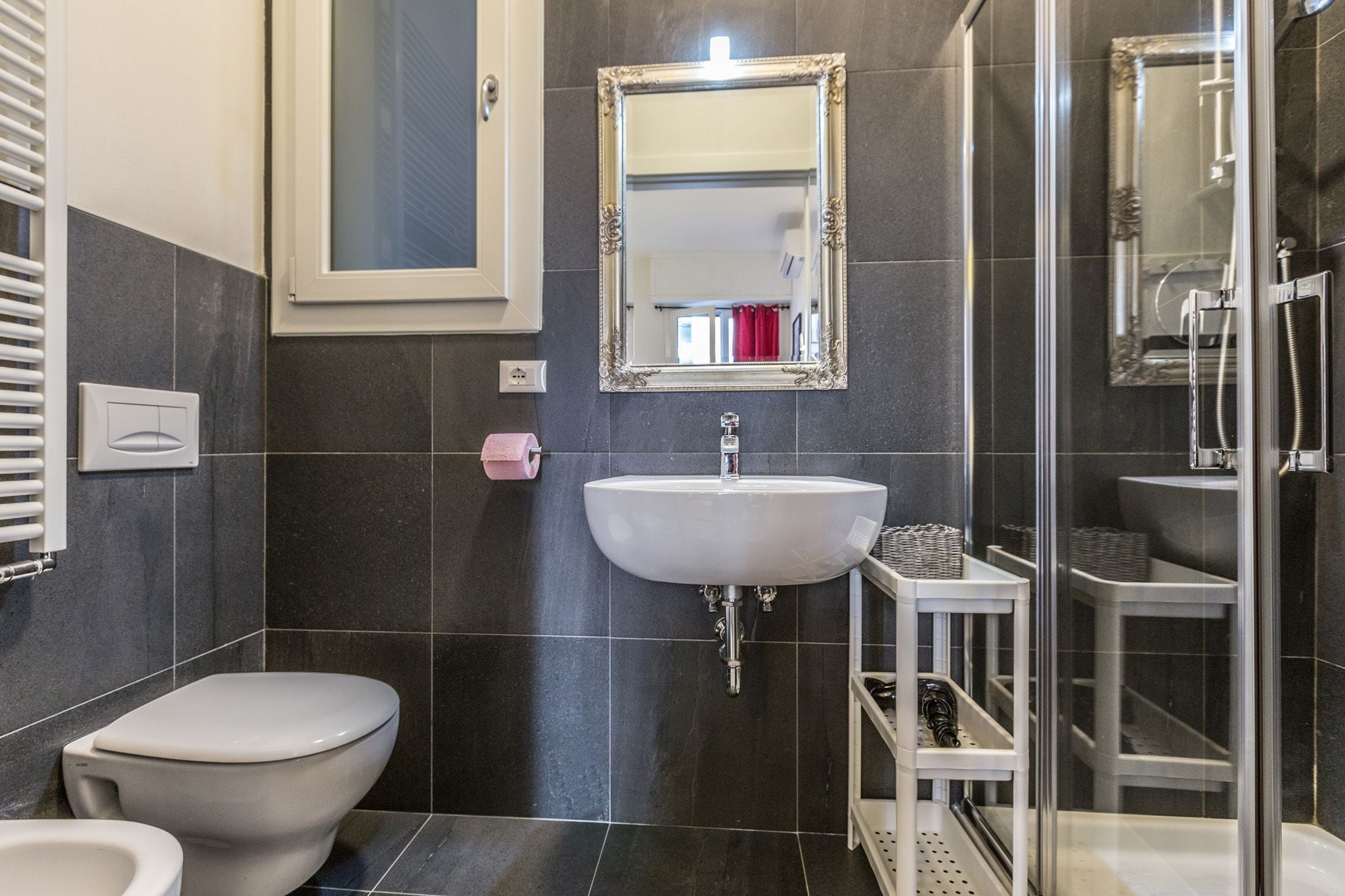 A modern bathroom with a toilet, sink, and shower.