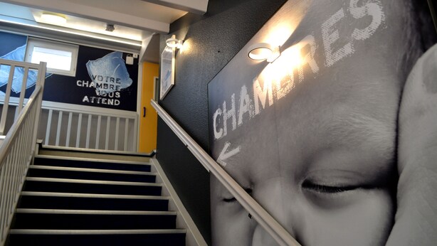 Una escalera con un cartel blanco y negro que muestra un rostro y la palabra 'CHAMPS'.