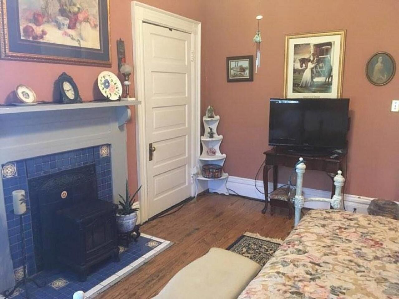 Una habitación con chimenea, televisión, cama y una mesita.