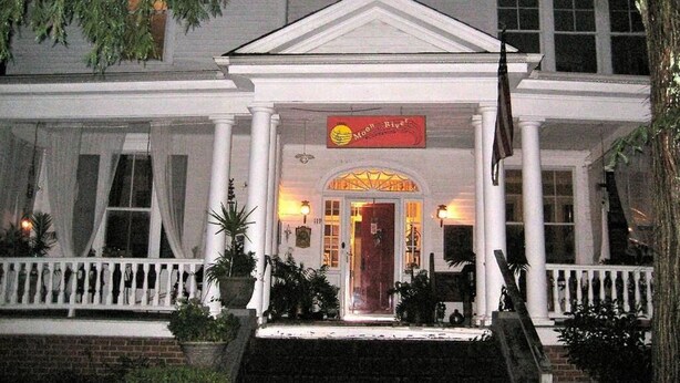 A white building with a red sign reading "Moon River."