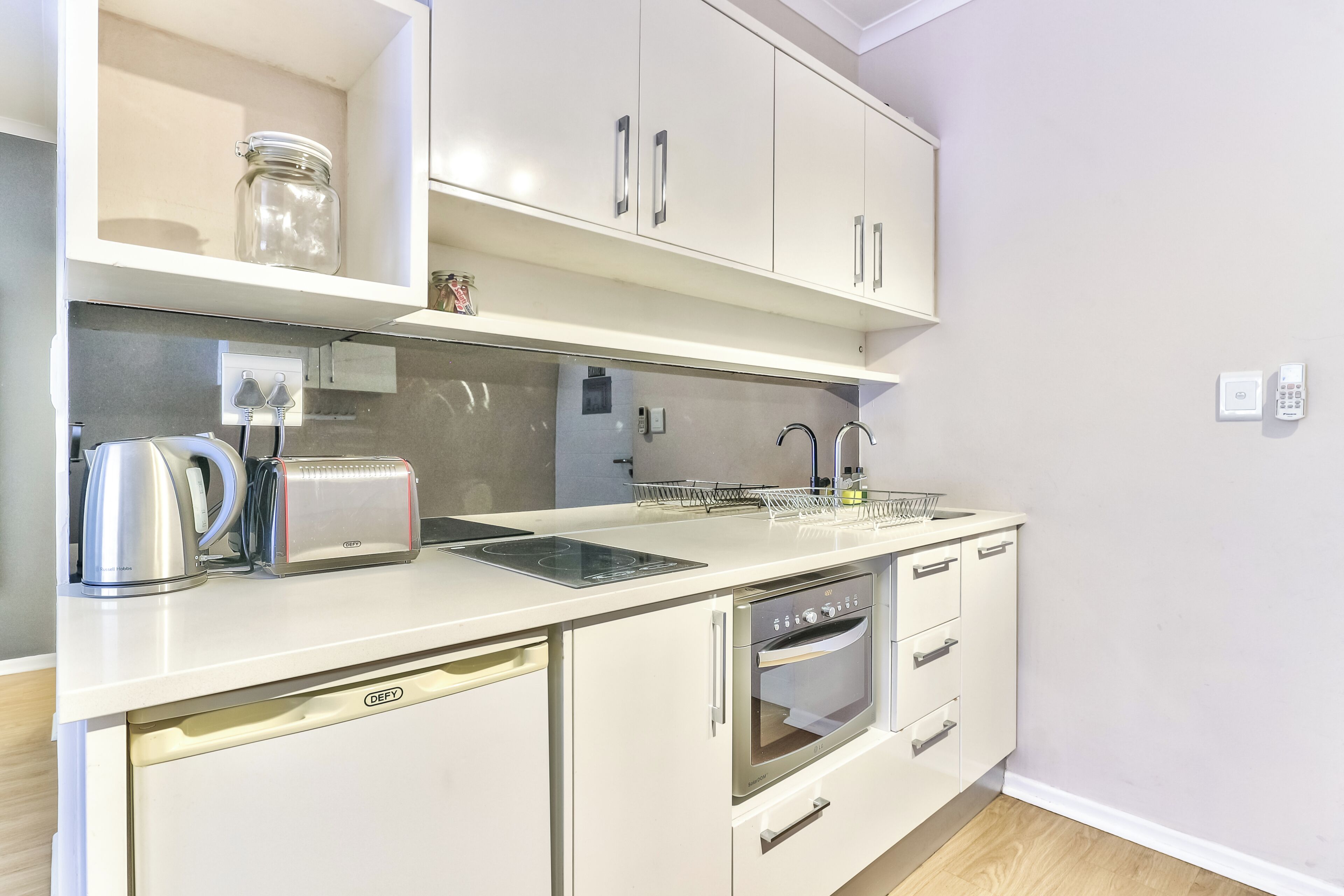 Una cocina equipada con horno, tostadora y hervidor.
