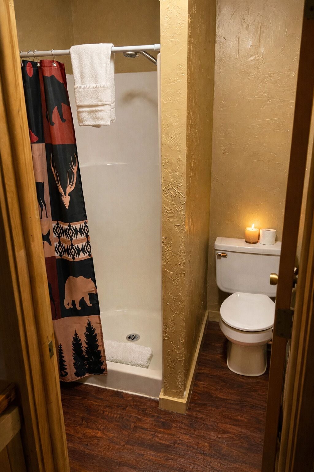 Een badkamer met douche, toilet en handdoekrek.