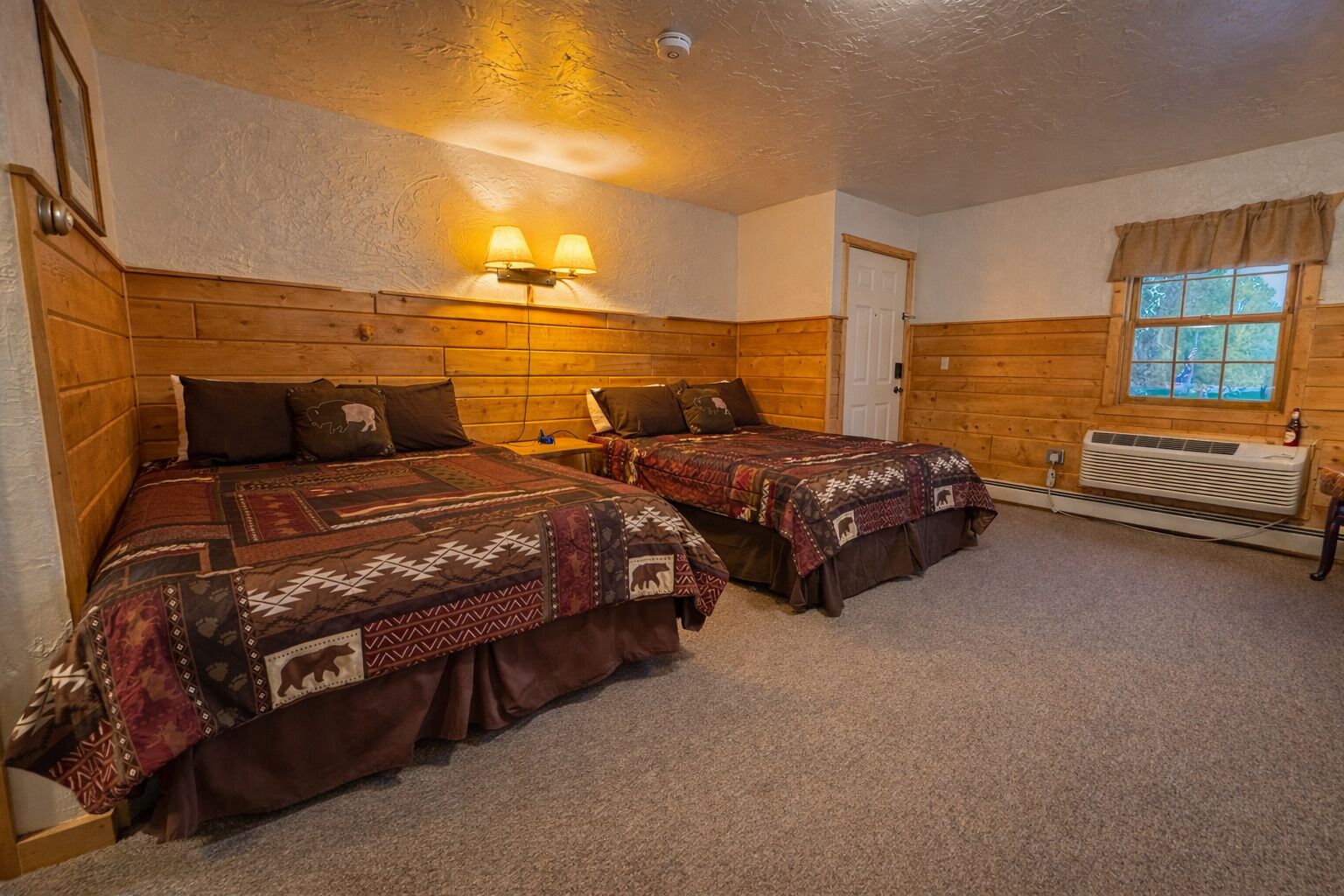 Ein gemütliches Zimmer mit zwei Betten, Holz-Kopfteilen, einem Fenster mit Vorhängen und einem Wandheizkörper.