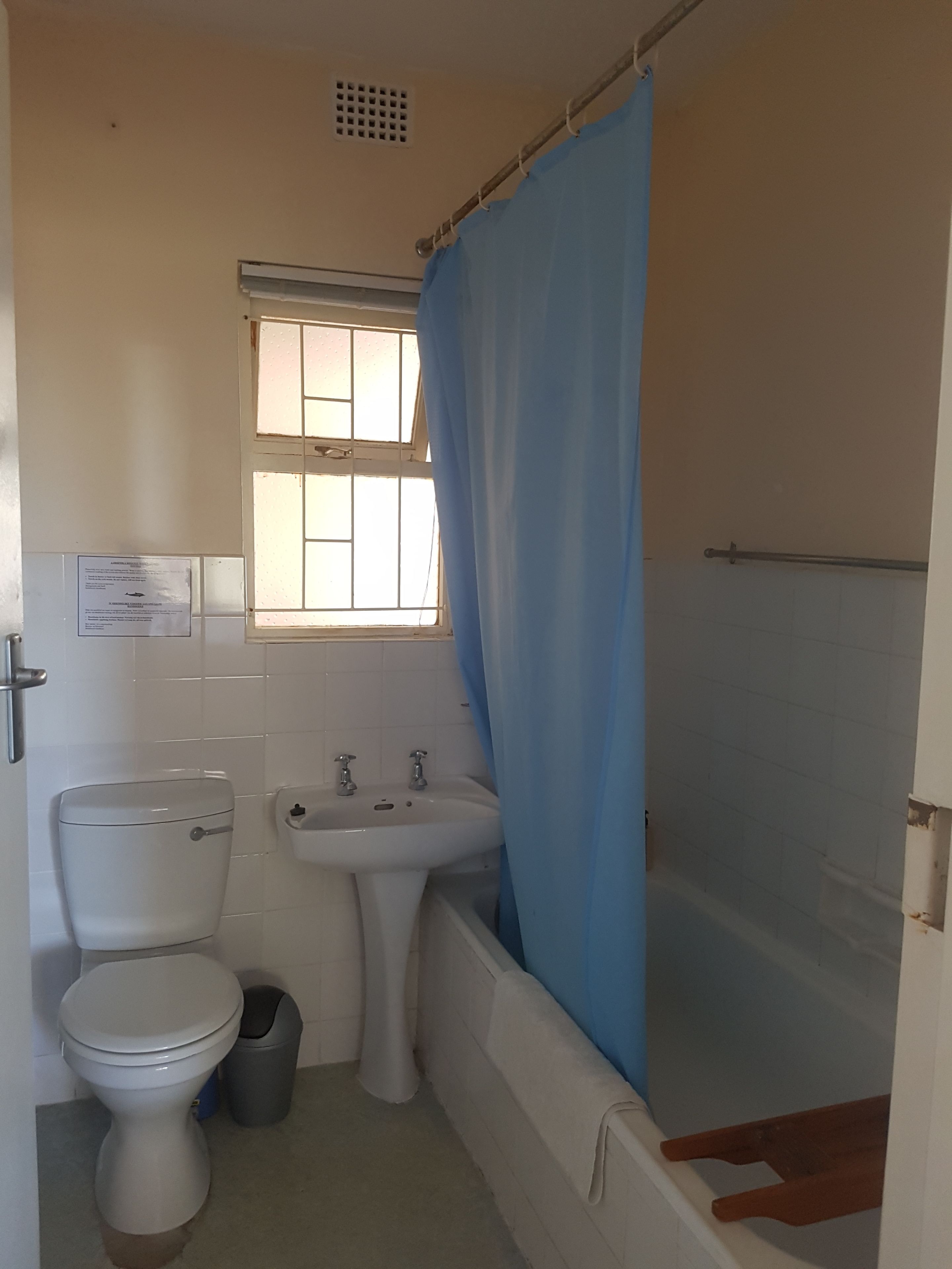 Une salle de bain avec des toilettes, un lavabo et une baignoire.