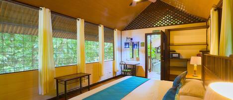 A bedroom with a bed, a ceiling fan, a window with curtains, and a door labeled "SALIDA".