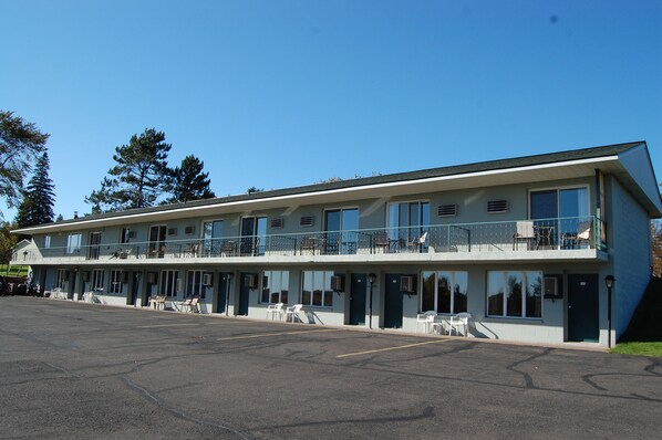 A motel with a two-story structure, multiple rooms, and a parking lot. - Northwoods Inn LLC (Barnum)