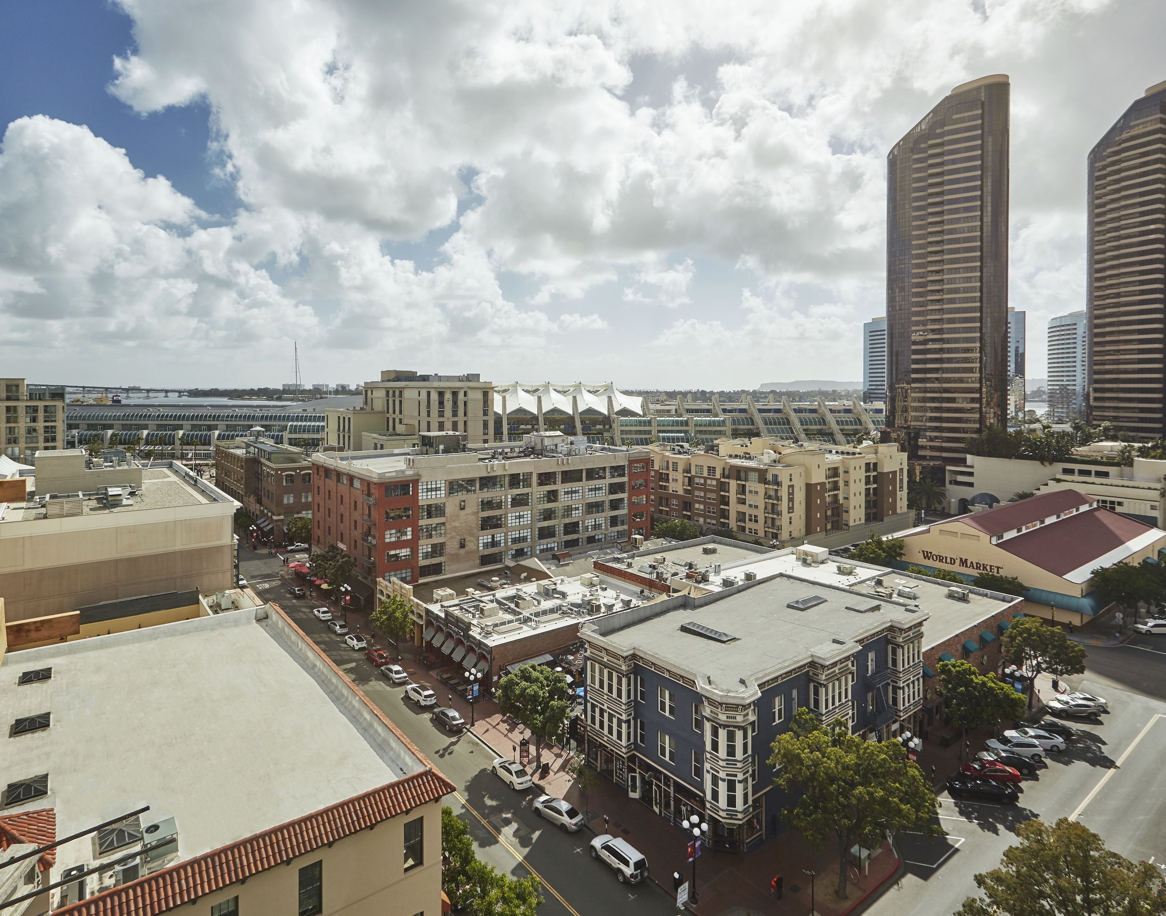 A cityscape with a variety of buildings, including a large commercial building with a sign that reads "WORLD MARKET".