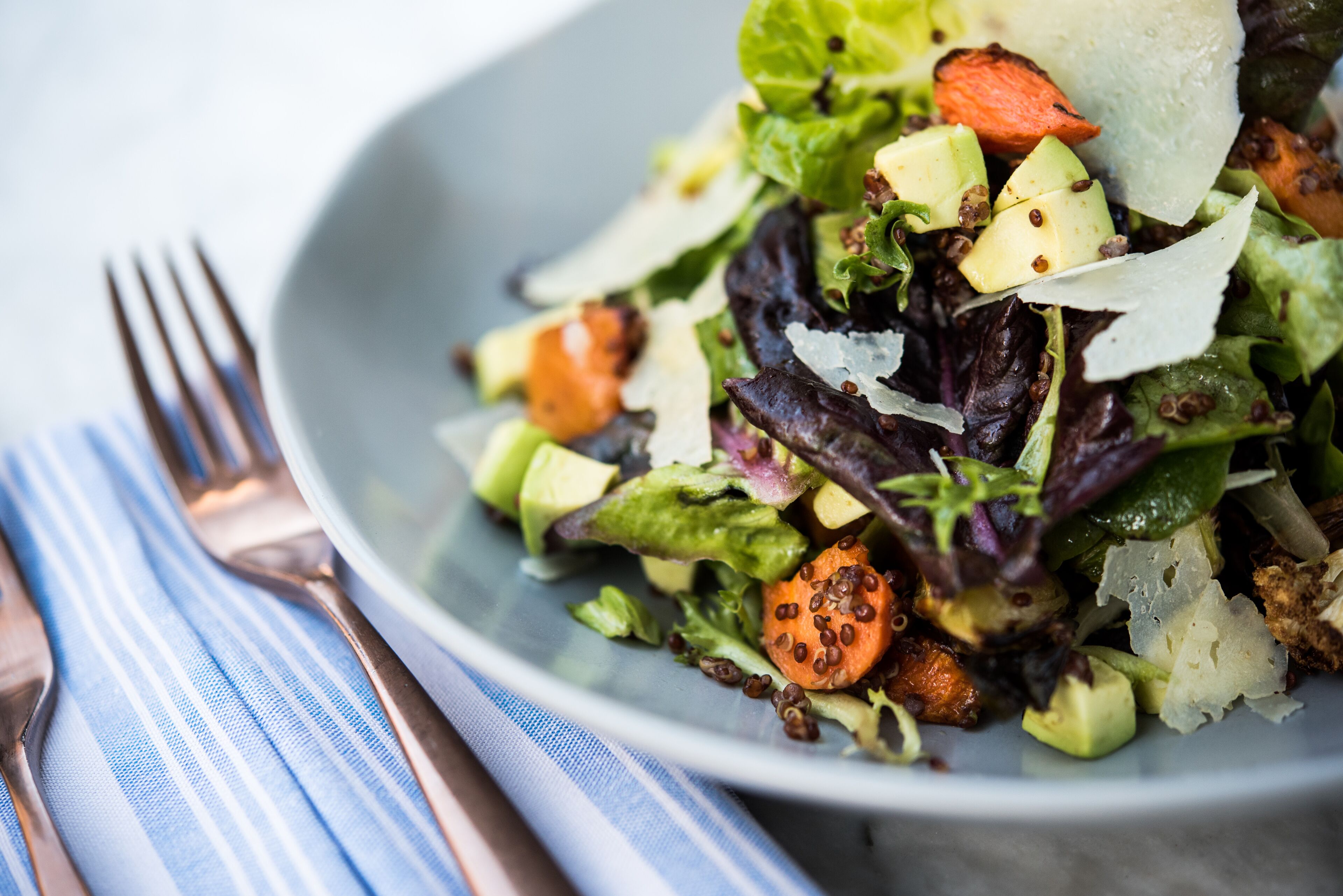 Un tazón de ensalada con diversos vegetales y queso.