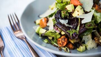 Un tazón de ensalada con diversos vegetales y queso.