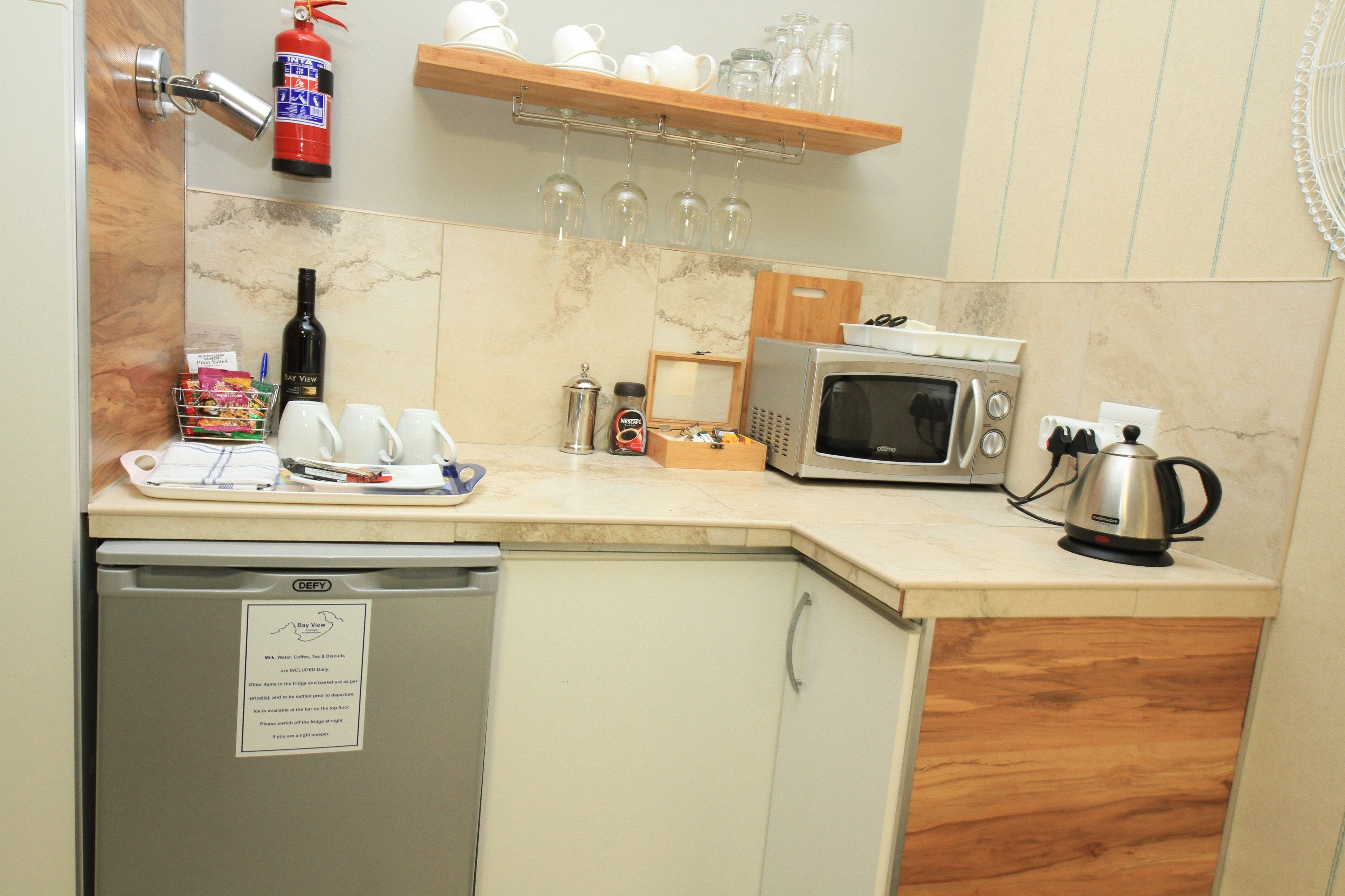 A compact kitchen with a microwave, coffee maker, and a small refrigerator.