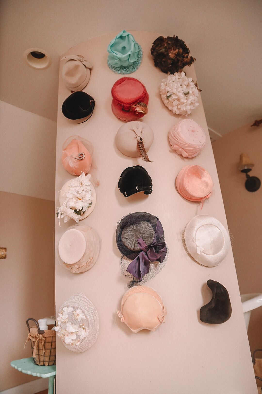 A wall with various hats displayed in a row.