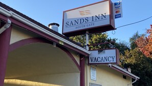 A hotel sign with "Sands Inn" and "Vacancy" indicating available rooms. - Sands Inn (South Gate)