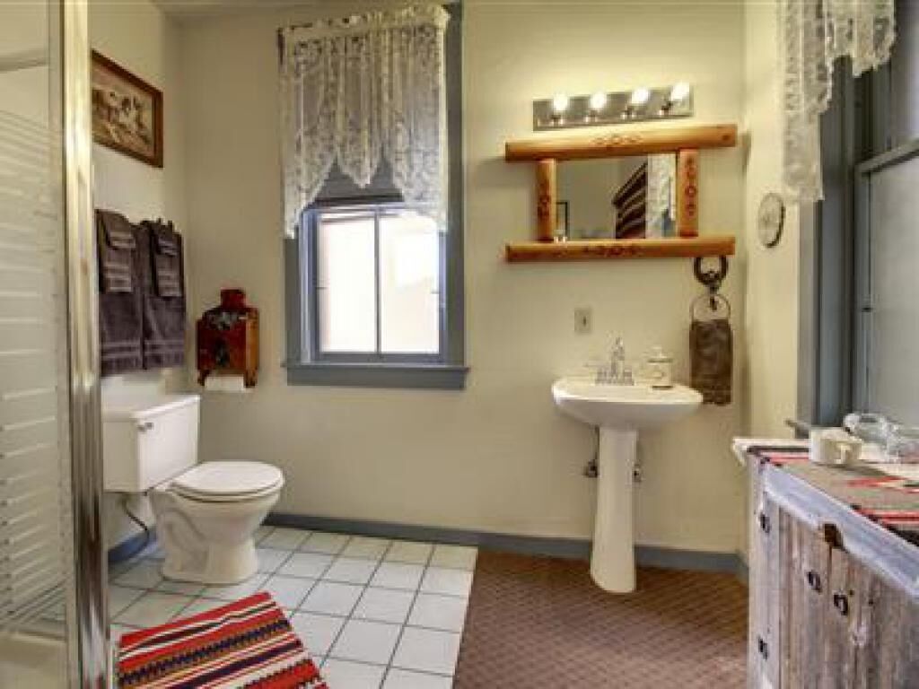 Une salle de bain avec des toilettes, un lavabo et une fenêtre.
