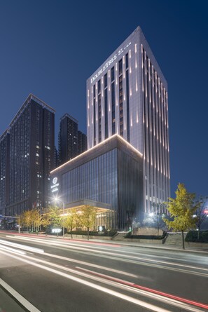 A modern hotel with a prominent 'DOUBLETREE' sign, featuring a sleek glass facade and a well-lit entrance. - DoubleTree by Hilton Hotel Shiyan (Shiyan)