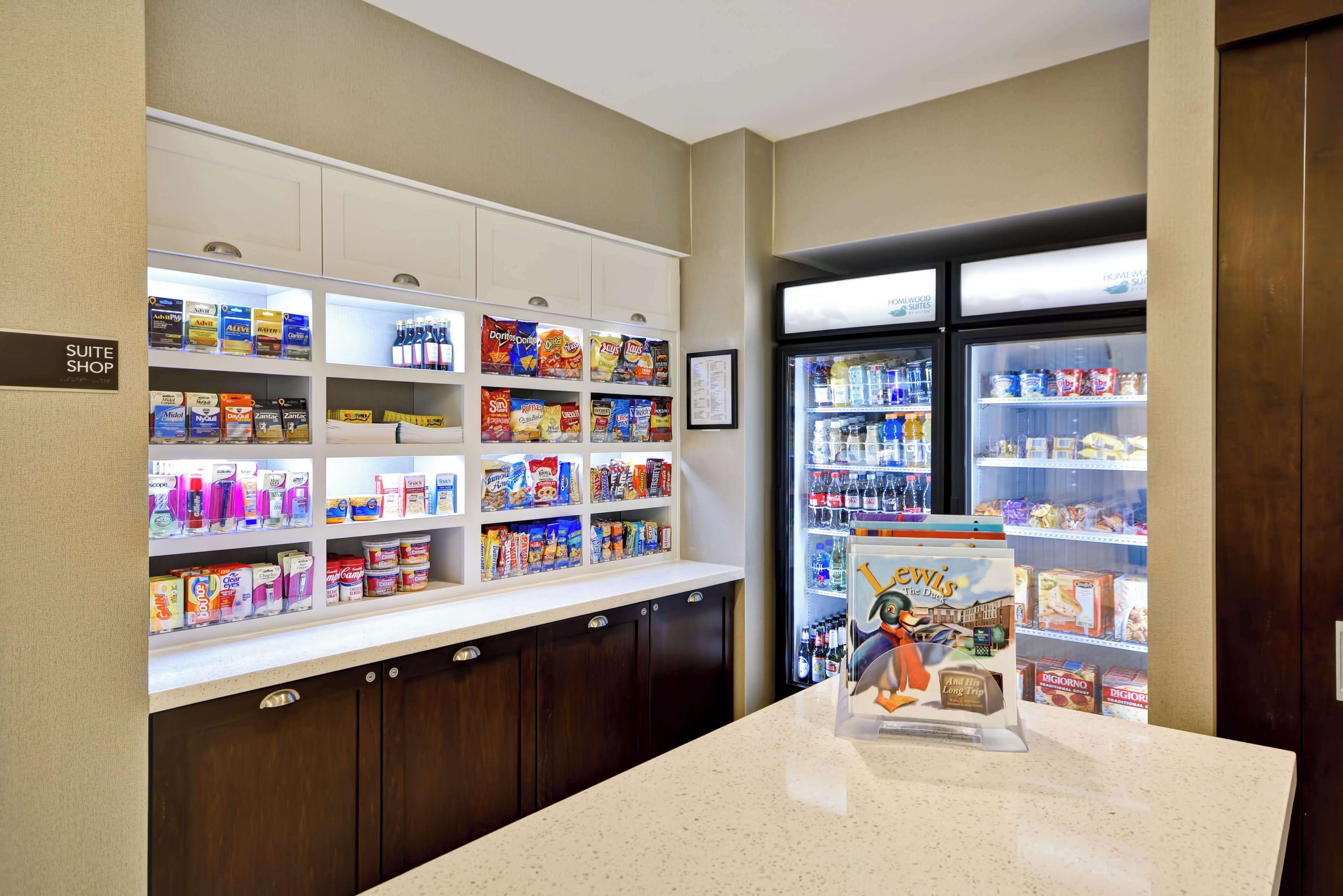 A hotel suite shop with shelves stocked with toiletries and snacks.