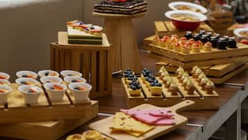 Ein Buffet mit verschiedenen Speisen, darunter Gebäck, Obst und Käse.