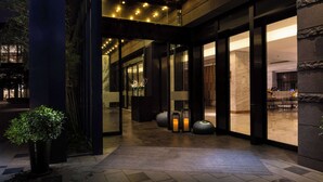 A modern hotel lobby with a dark-toned reception area, a large potted plant, and a well-lit ceiling. - DoubleTree by Hilton Shanghai Hongqiao (Shanghai)