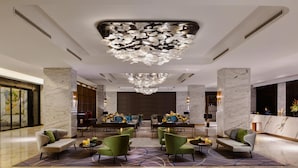 A lobby with a modern chandelier, marble columns, and seating areas. - DoubleTree by Hilton Shanghai Hongqiao (Shanghai)