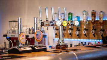 Um bar com várias torneiras de cerveja, incluindo marcas como Carling e Guinness.
