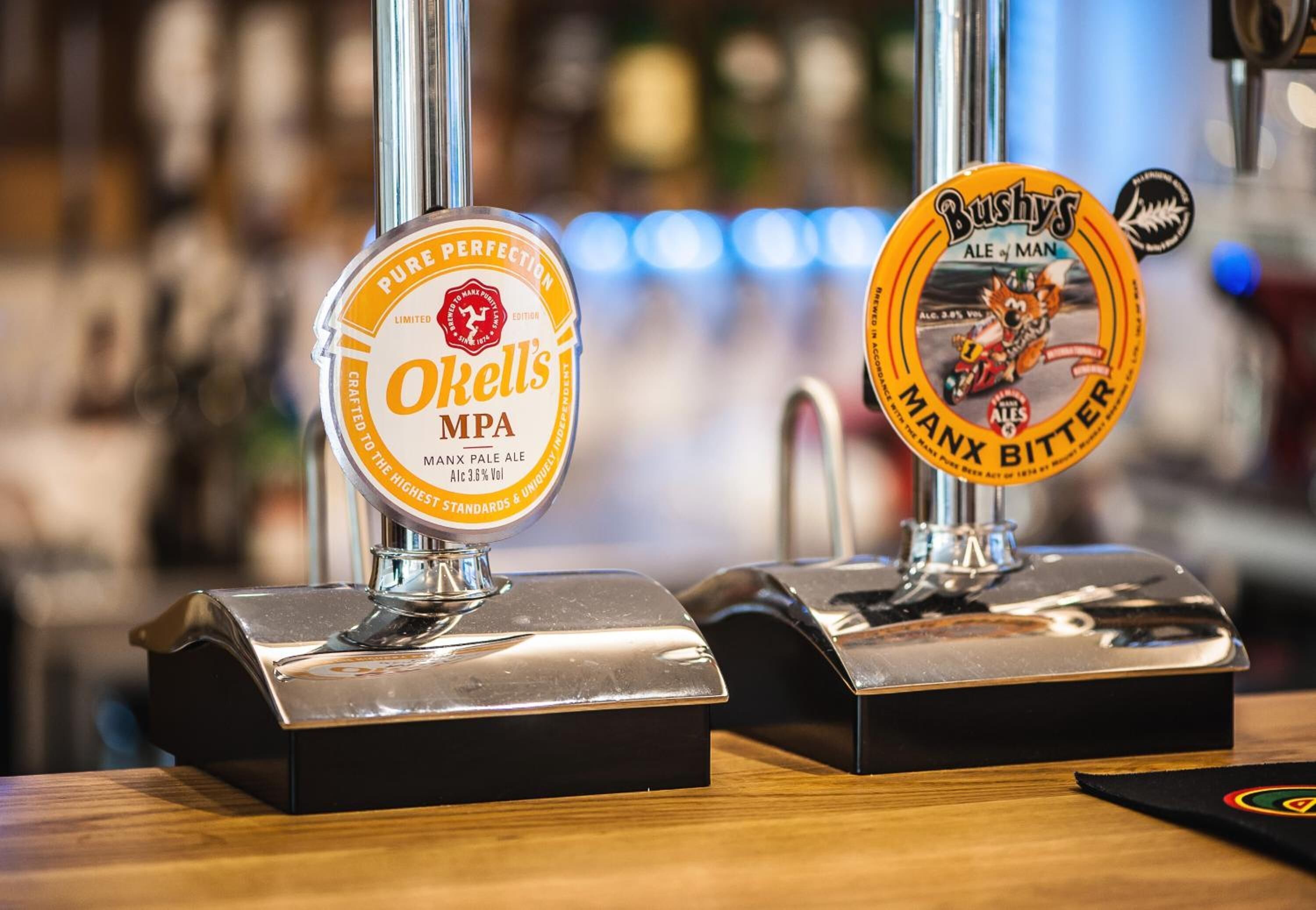 Two beer taps with labels: O'Kelly's MPA and Bushy's Ale of Man.