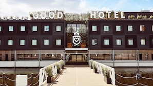 A hotel with a symmetrical facade, a central entrance, and a water body in front. - Good Hotel London (London)