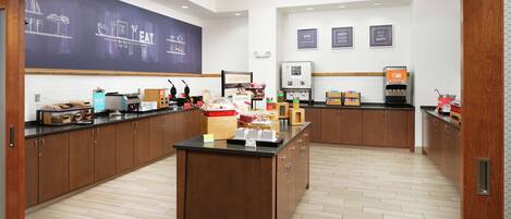 A modern kitchen with wooden cabinets, a central island, and a chalkboard wall with kitchen-related drawings.
