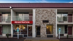 A building with a registration sign, multiple balconies, and a stone facade. - Red Roof Inn Dumfries - Quantico (Dumfries)