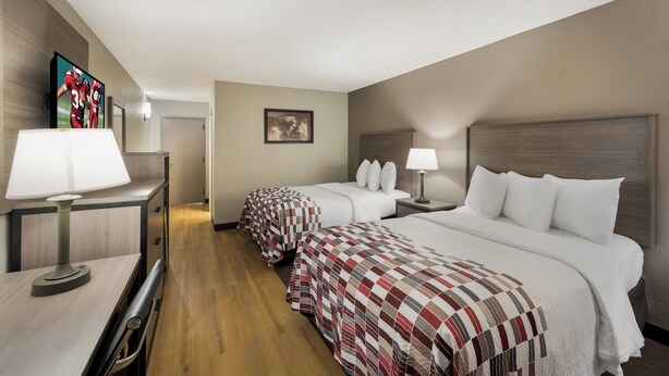 A hotel room with two beds, a desk with a lamp, a TV, and a framed picture on the wall. - Red Roof Inn Dumfries - Quantico (Dumfries)
