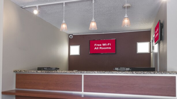 A reception desk with a sign indicating free Wi-Fi availability. - Red Roof Inn Dumfries - Quantico (Dumfries)