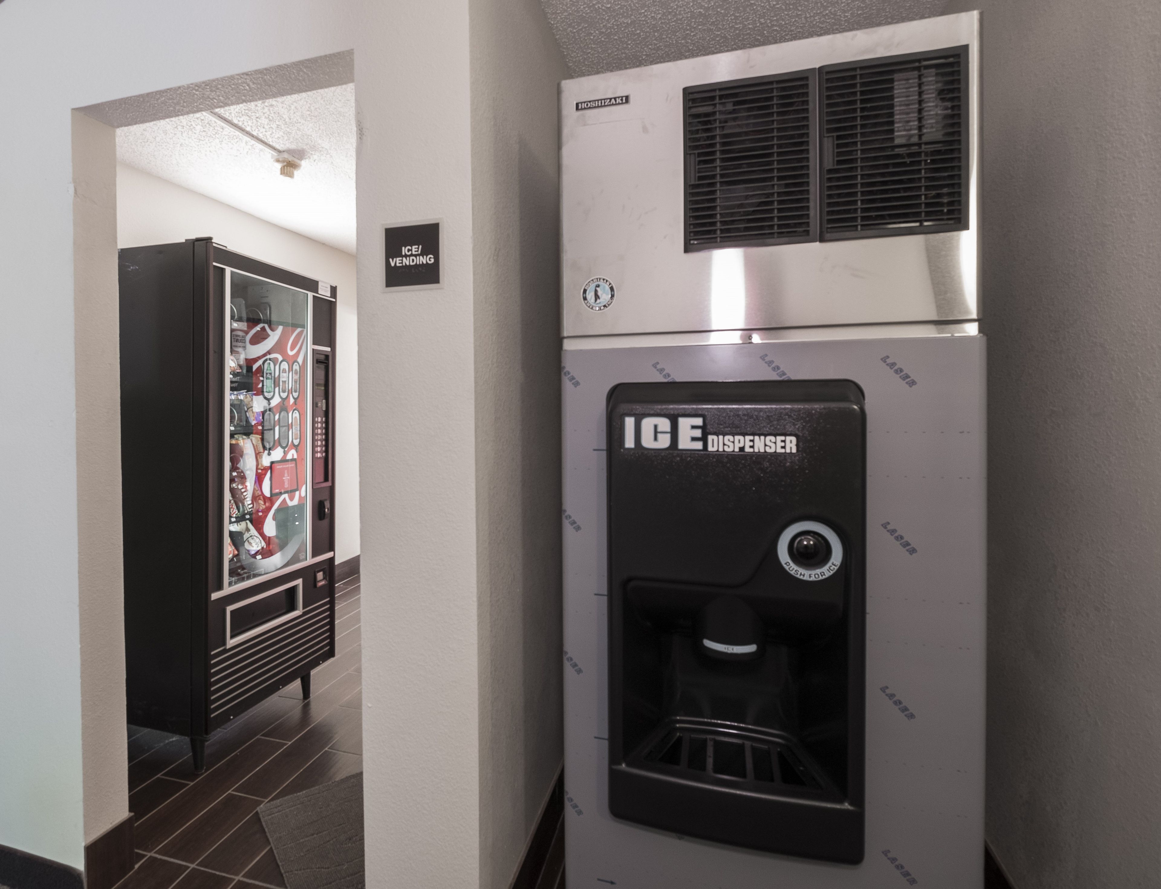 A hallway with an ice dispenser and vending machine.