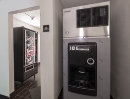A hallway with an ice dispenser and vending machine.