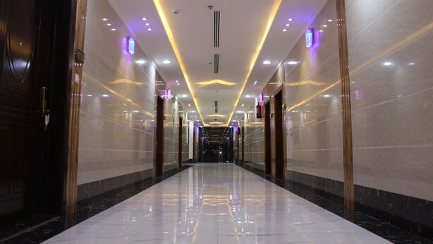 A long, well-lit hallway with reflective floors and modern lighting fixtures.