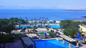 A resort with a large pool, palm trees, and a water park.