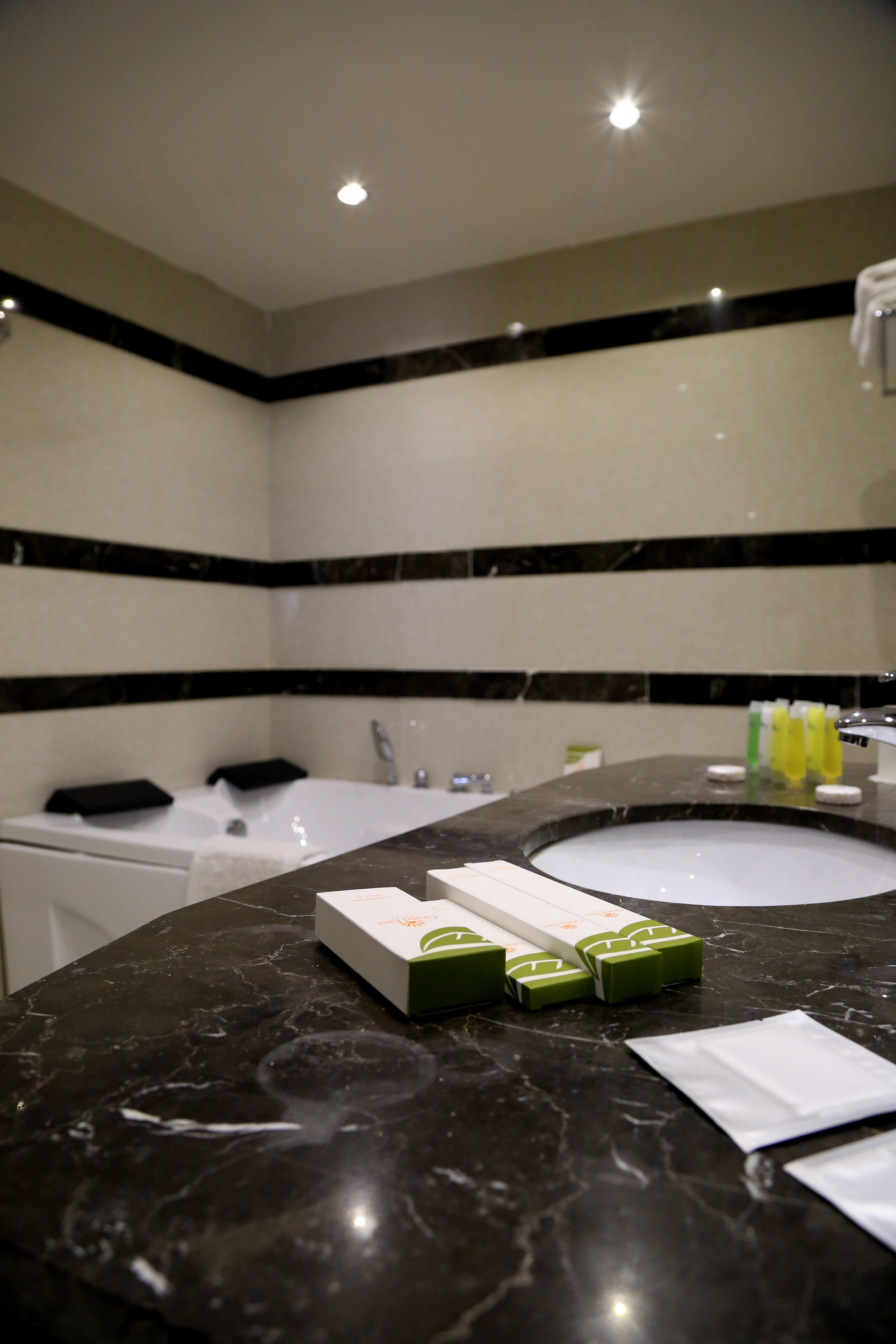 A bathroom with a bathtub, a sink, and toiletries.