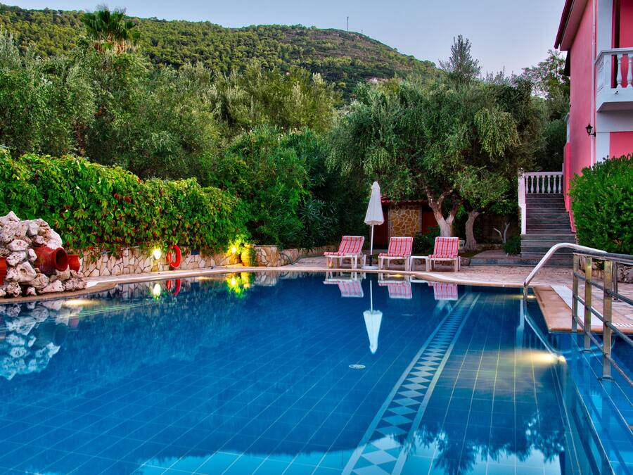 Una piscina al aire libre, sombrillas, tumbonas