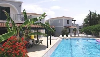 Una piscina al aire libre de temporada, sombrillas, tumbonas