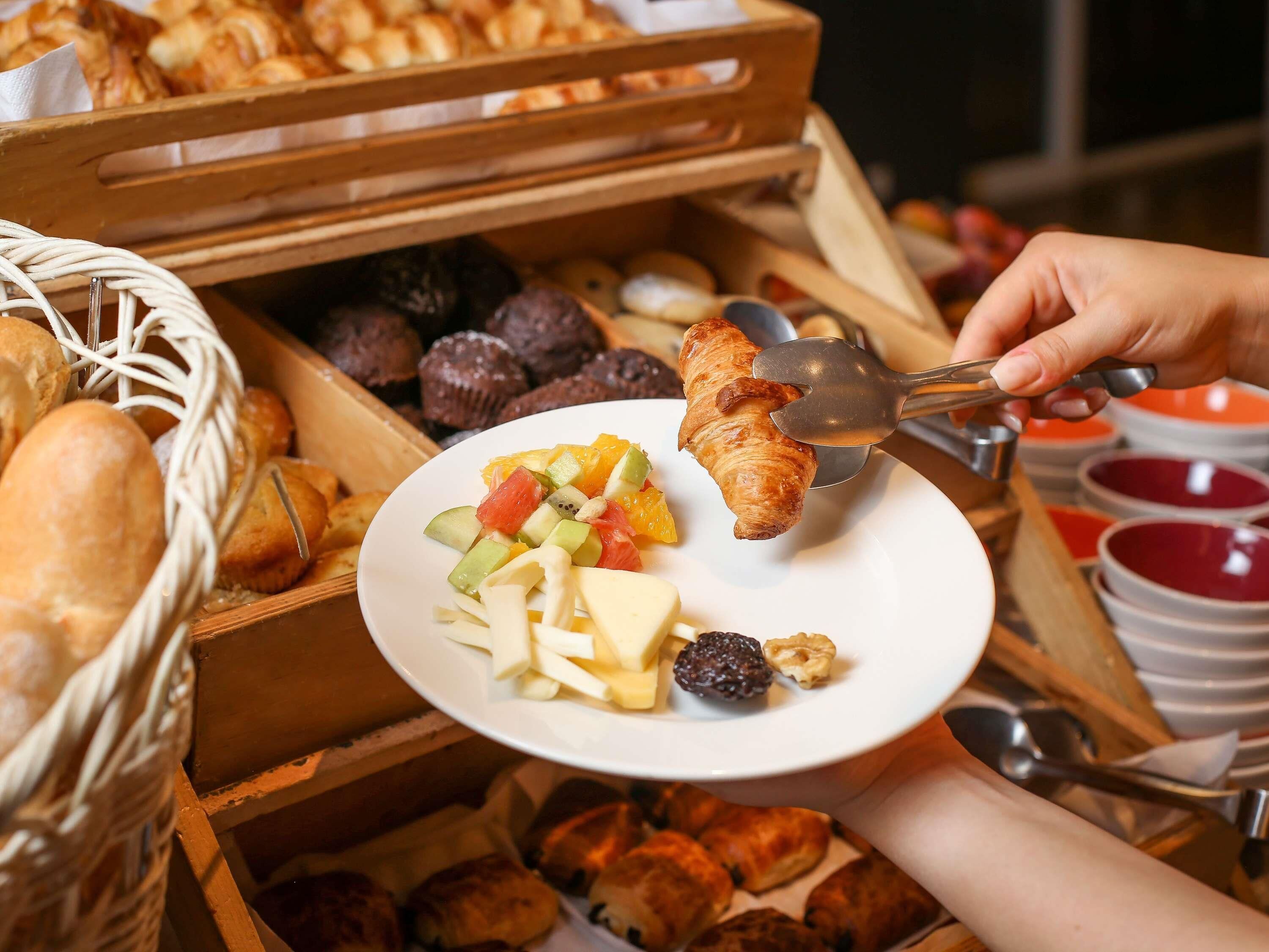 A breakfast buffet with various pastries and fruits.
