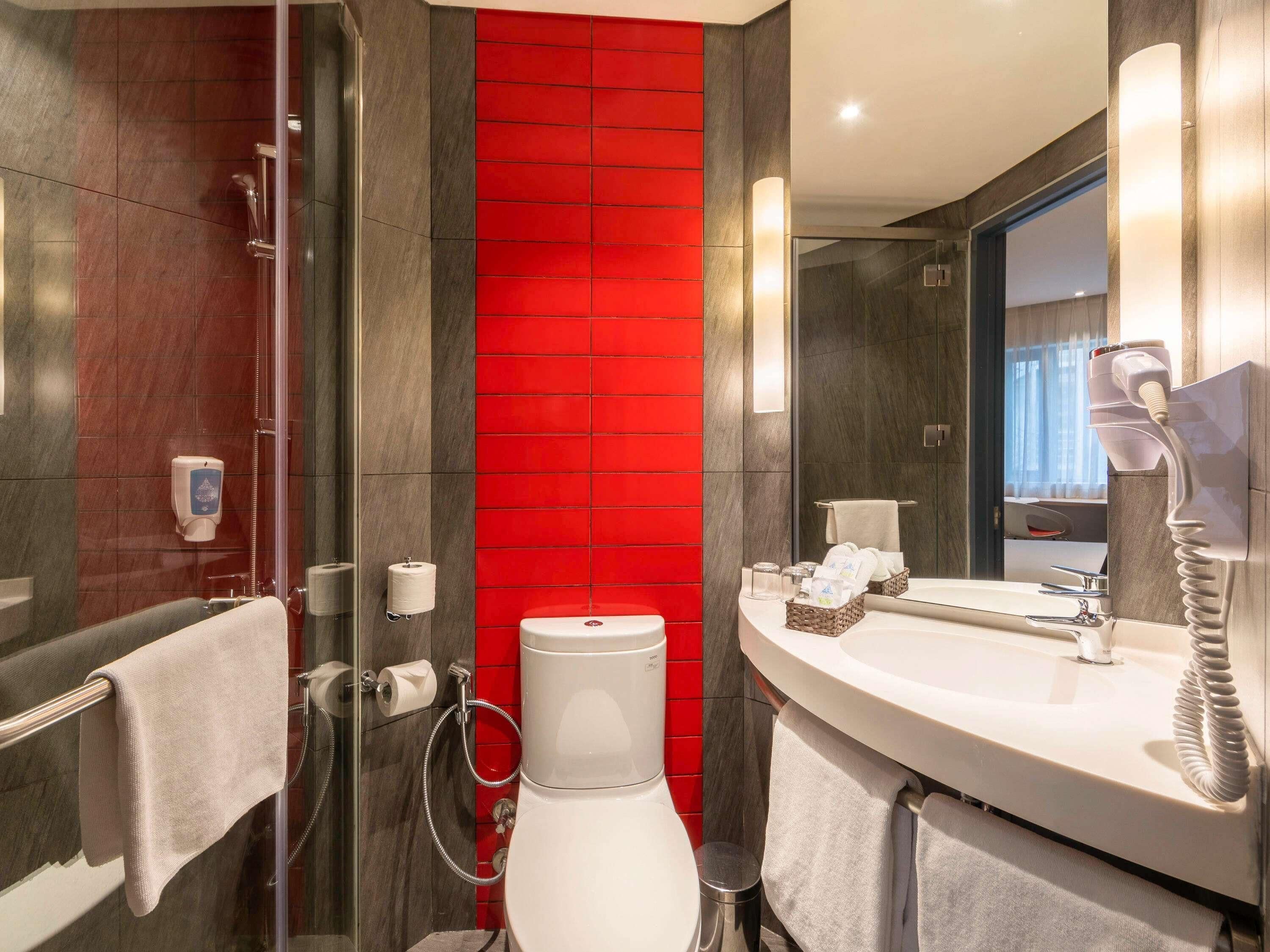 A modern bathroom with a glass-enclosed shower, a white toilet, and a vanity with a mirror.