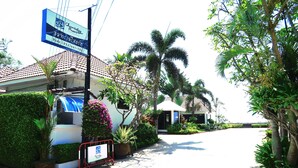 A resort entrance with a sign, palm trees, and a tiled roof. - Chomtalay Resort at Had Chaosamran Beach (Ban Laem)