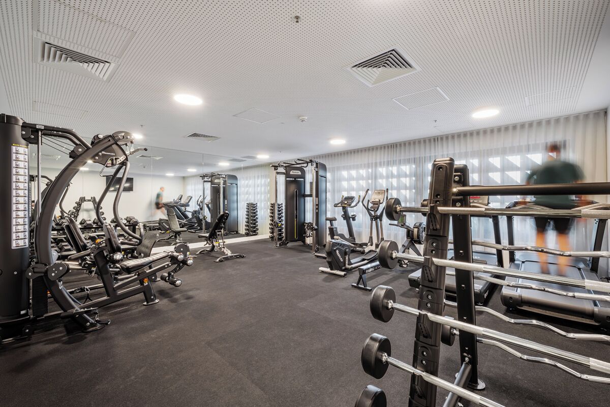 Un gimnasio con diferentes máquinas de ejercicio, cintas de correr y equipo de levantamiento de pesas.