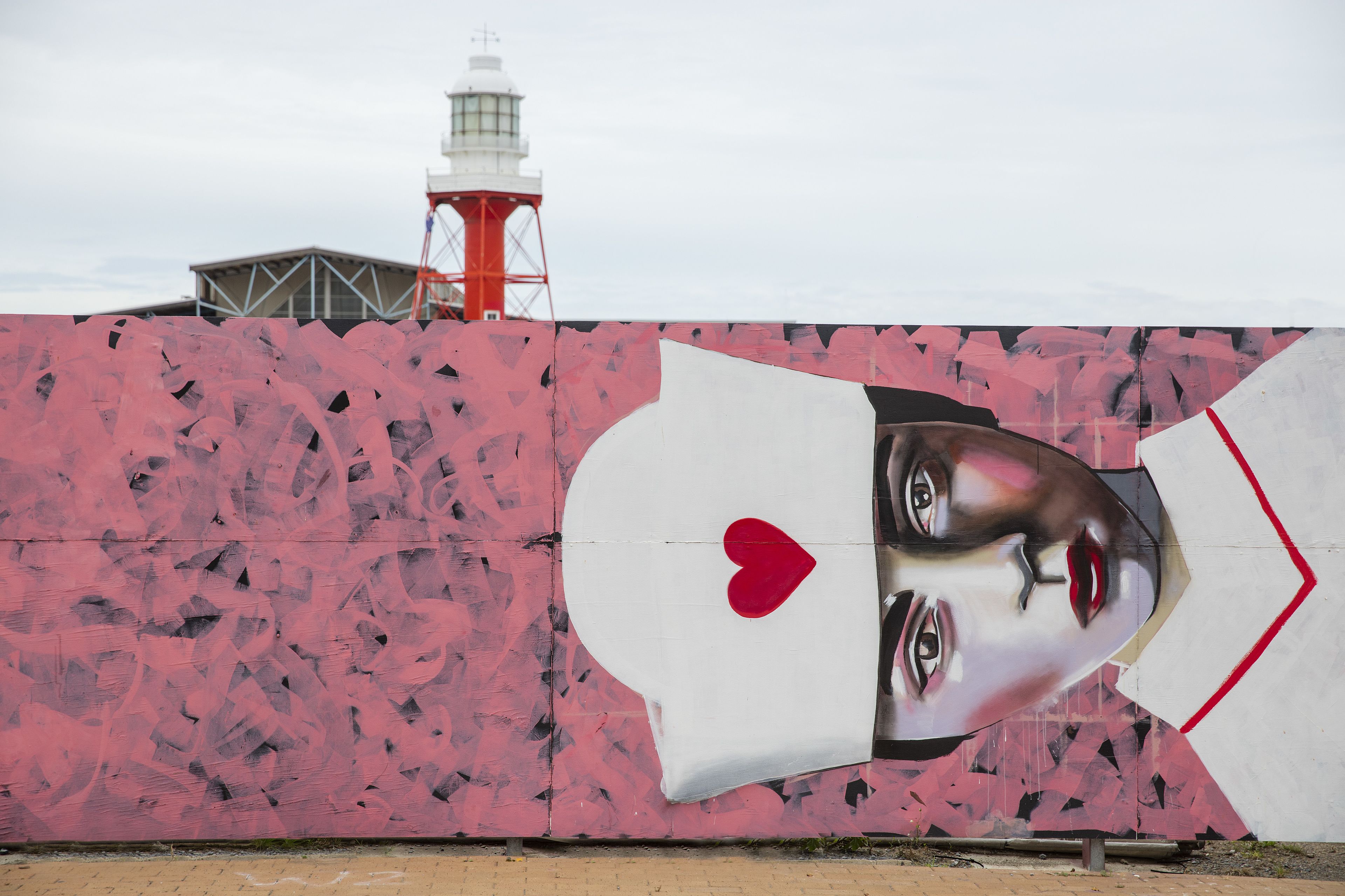 A wall with a large, abstract painting featuring a heart and a face.