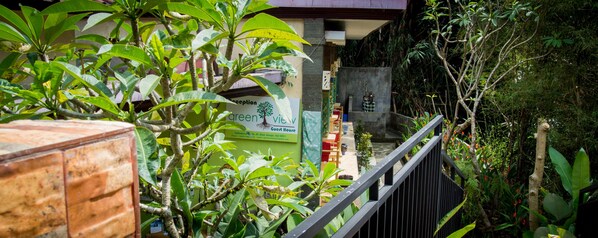 Uma área de recepção com uma placa indicando 'green view guest house' e uma escadaria que leva a uma varanda.
