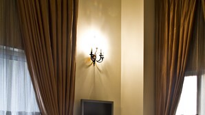 Una habitación de hotel con una cama grande, un televisor de pantalla plana montado en la pared y una mesita de noche con un control remoto.