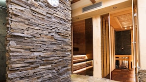 A stone wall with a wooden door leading to a room with a fireplace. - Hotel Anglický Dvůr (Karlovy Vary)
