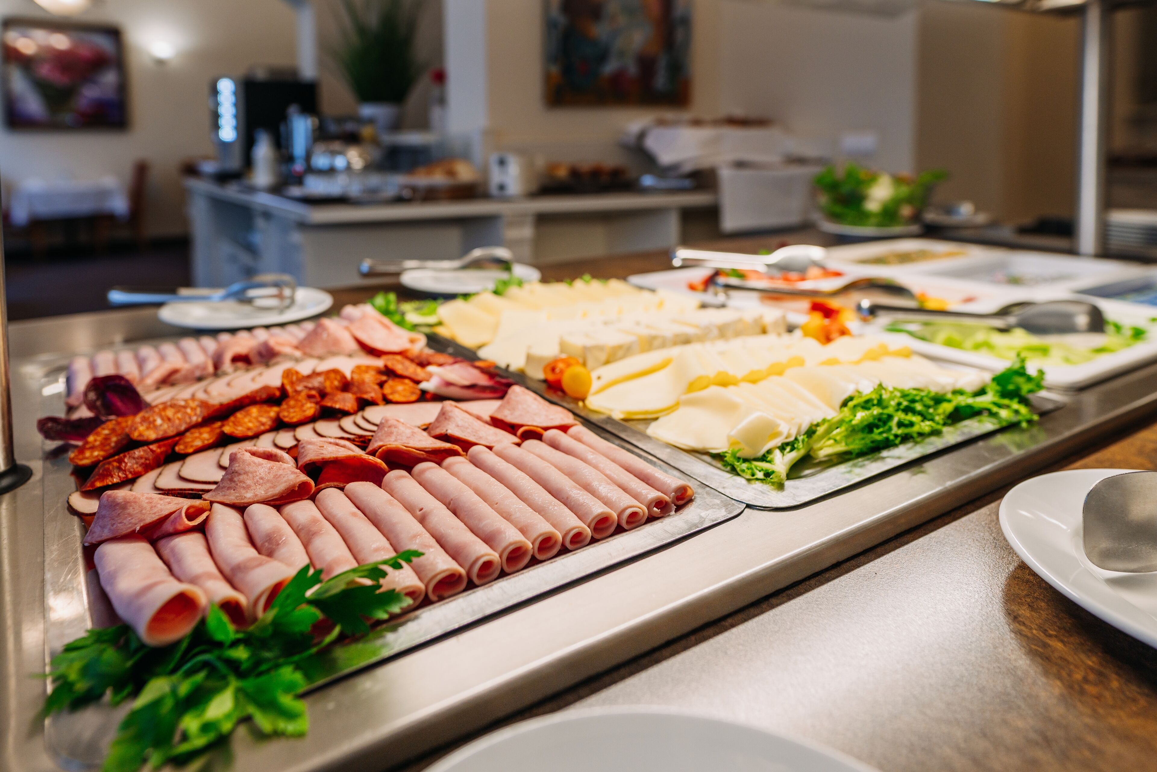 A buffet with various meats and cheeses.