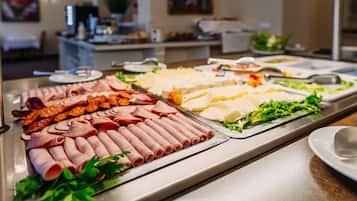 A buffet with various meats and cheeses.