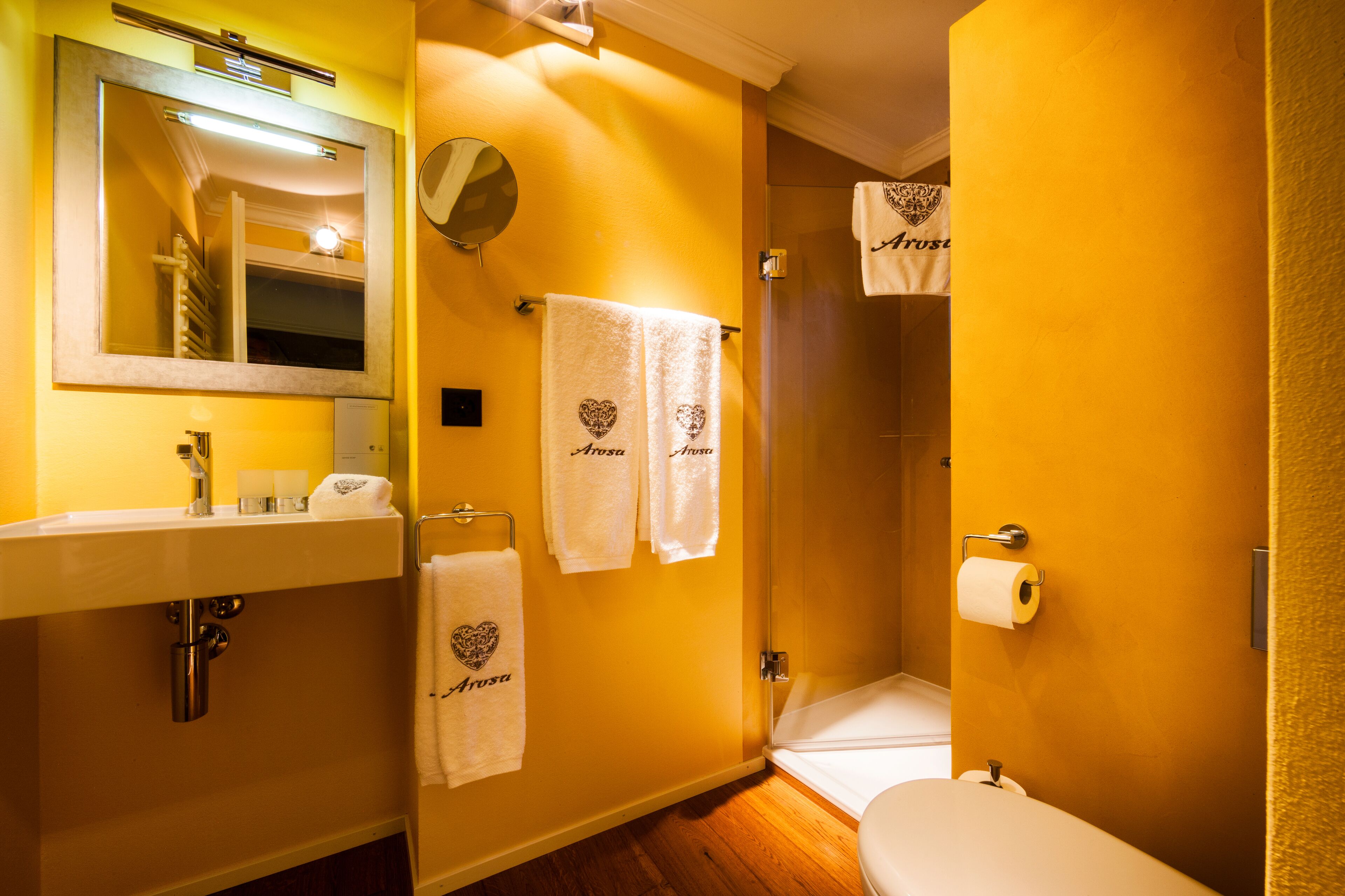 A bathroom with a sink, mirror, towel rack, and toilet.