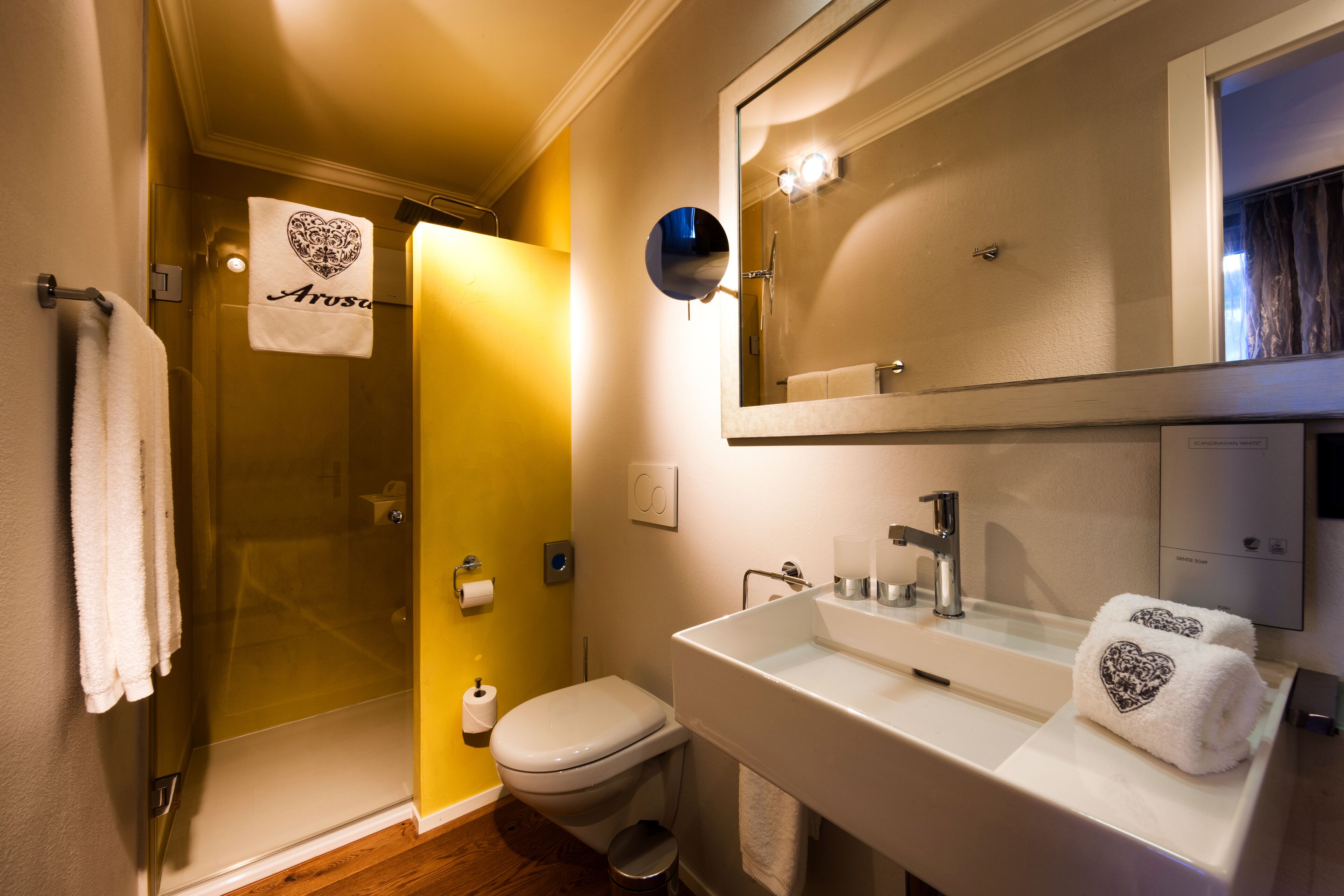 Un baño con ducha, inodoro, lavabo y espejo.