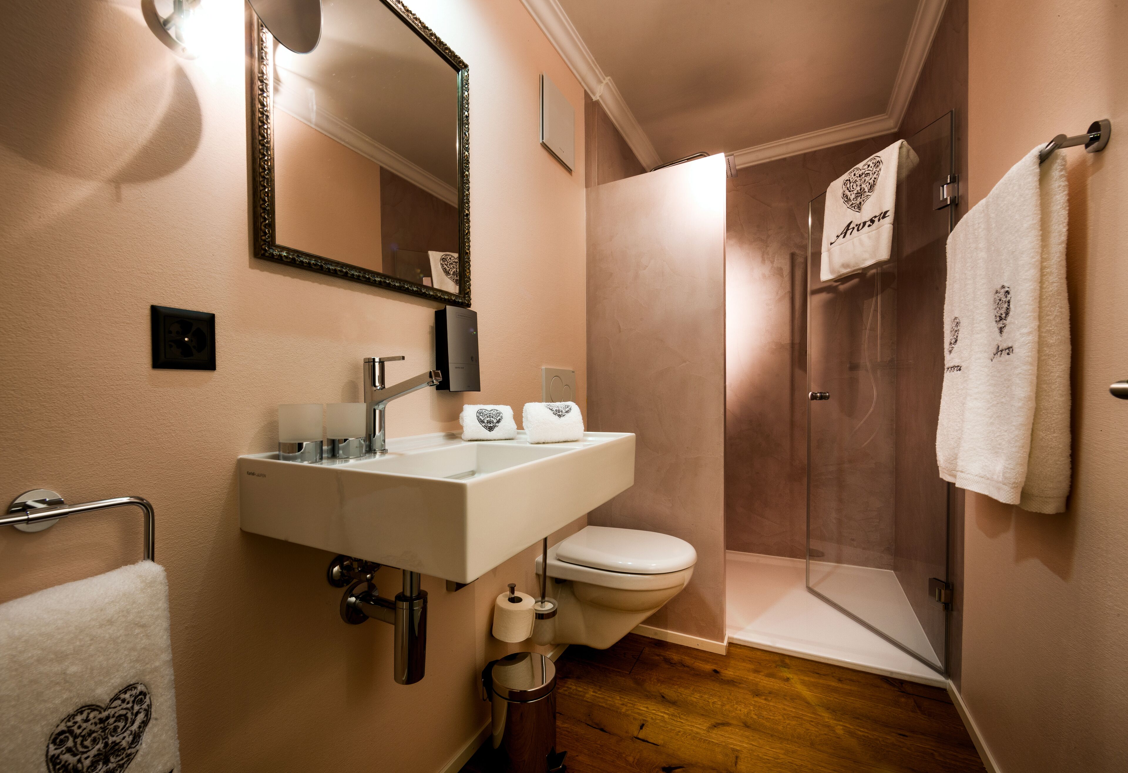 A bathroom with a sink, toilet, and glass shower enclosure.